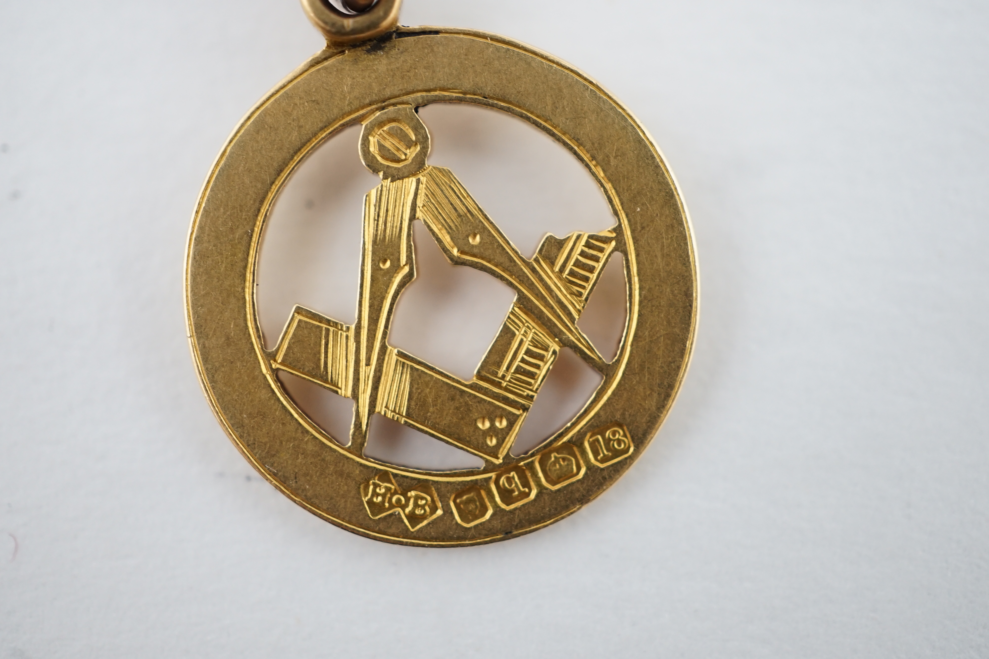 An Edwardian 9ct gold curb link albert, hung with a 9ct gold Masonic charm, locket and a double sided portrait pendant